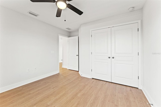 unfurnished bedroom with light wood-type flooring, a closet, visible vents, and baseboards