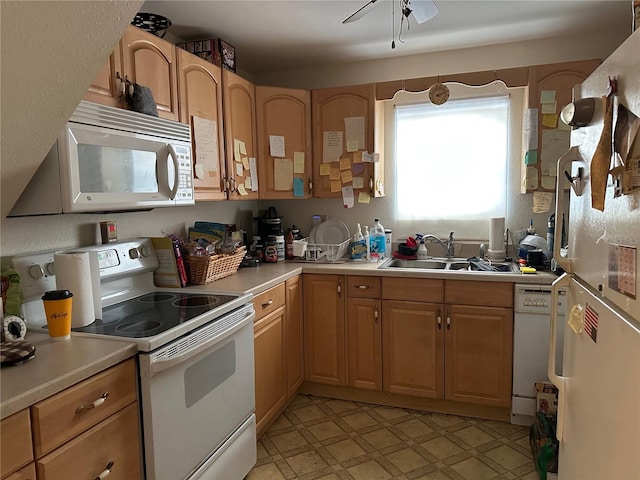 kitchen featuring white appliances, light countertops, a sink, and light floors