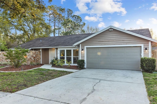 ranch-style home with concrete driveway, a garage, and a shingled roof