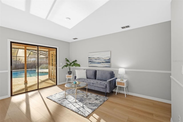 sitting room with light wood-style flooring, baseboards, and visible vents