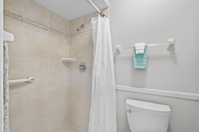 bathroom featuring a tile shower and toilet