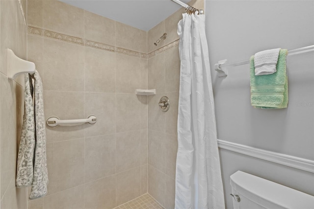 full bathroom with tiled shower and toilet