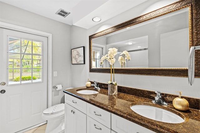 full bath with double vanity, toilet, visible vents, and a sink