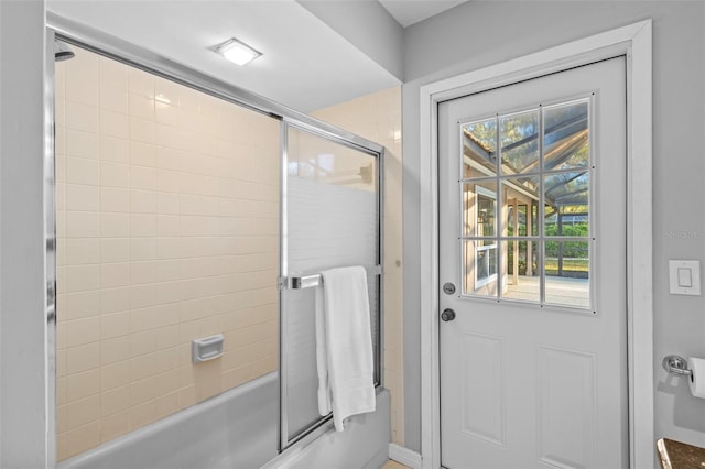 bathroom featuring combined bath / shower with glass door