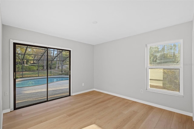 unfurnished room with baseboards and light wood-style floors