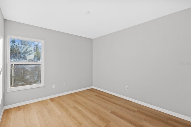 unfurnished room featuring baseboards and light wood-style floors