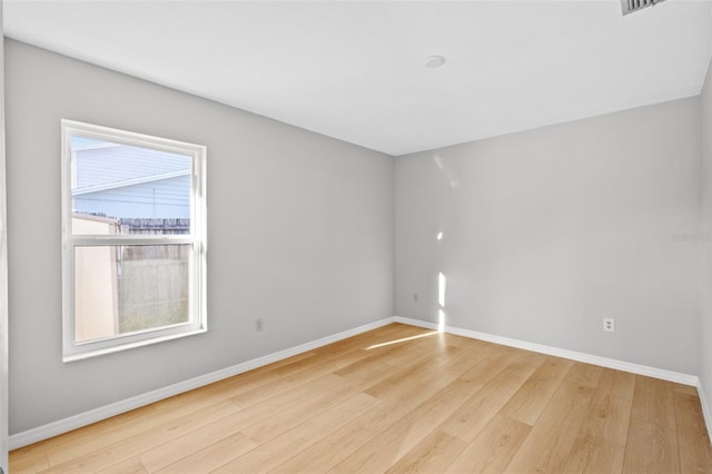 unfurnished room with baseboards and wood finished floors