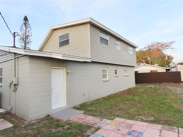 rear view of property with fence and a lawn