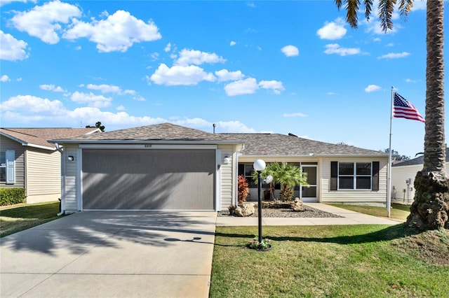 view of front of home featuring a garage, concrete driveway, and a front lawn