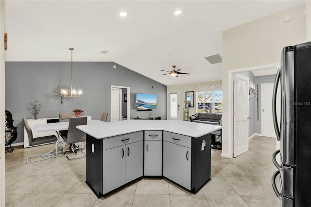 kitchen with open floor plan, light countertops, hanging light fixtures, gray cabinets, and freestanding refrigerator