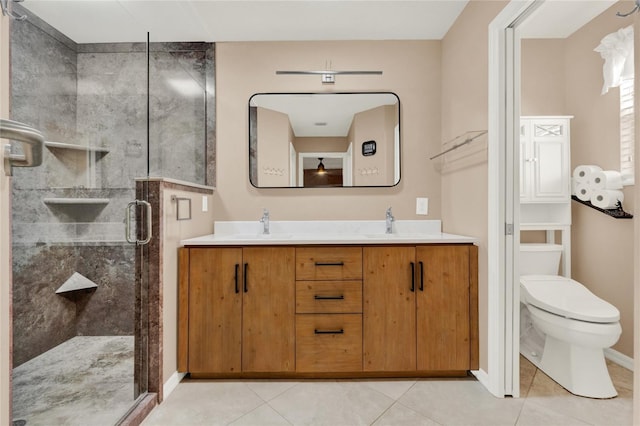 full bathroom with double vanity, a stall shower, toilet, tile patterned flooring, and a sink