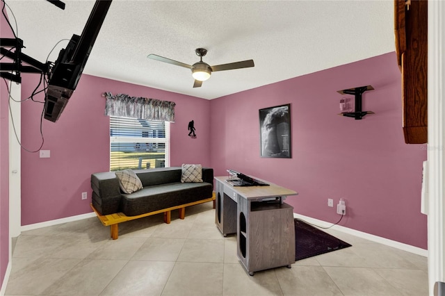 living room featuring a textured ceiling, light tile patterned floors, a ceiling fan, and baseboards