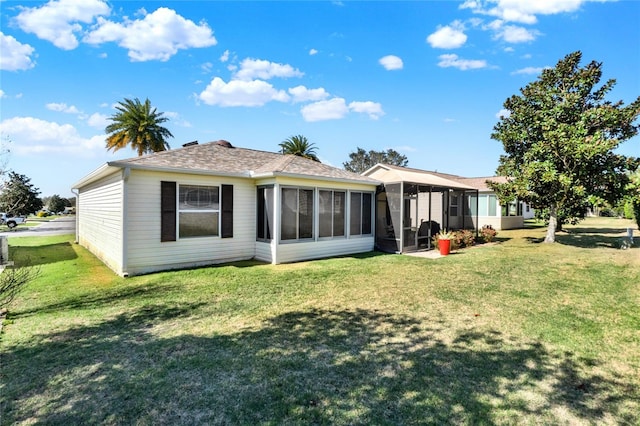 back of property with a sunroom and a lawn