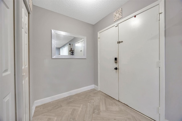 interior space featuring a textured ceiling and baseboards