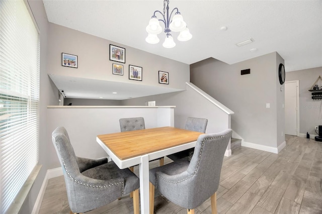 dining area featuring stairs, a chandelier, wood finished floors, and baseboards