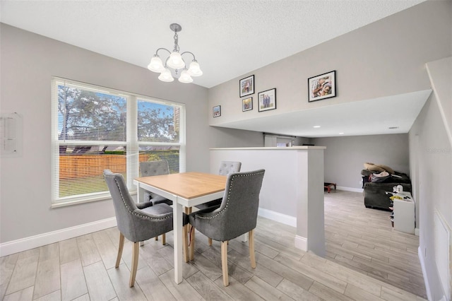 dining room featuring baseboards, wood tiled floor, a chandelier, and a textured ceiling