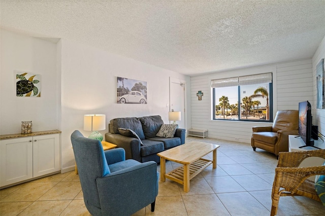 living area featuring a textured ceiling and light tile patterned flooring