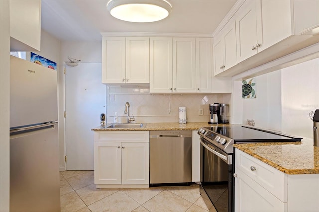 kitchen with light tile patterned floors, decorative backsplash, stainless steel appliances, and a sink