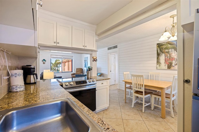 kitchen featuring light tile patterned flooring, a sink, visible vents, white cabinets, and electric stove