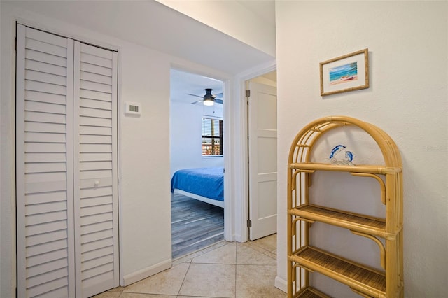 hall featuring baseboards and light tile patterned floors