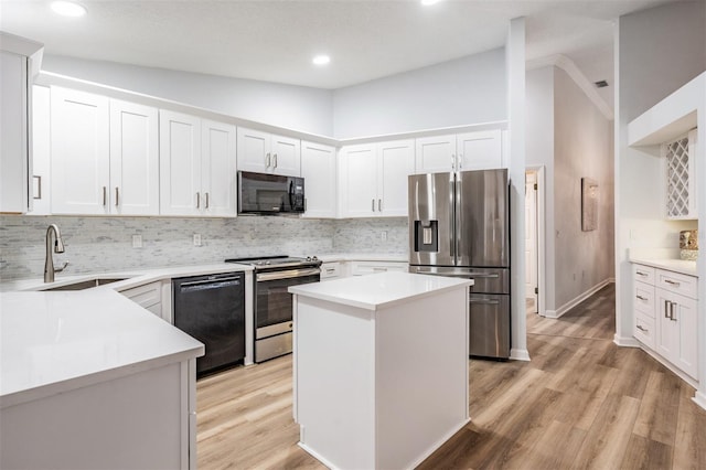 kitchen featuring white cabinets, black appliances, light countertops, and a sink