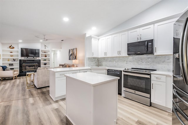 kitchen featuring a peninsula, black appliances, white cabinets, and light countertops