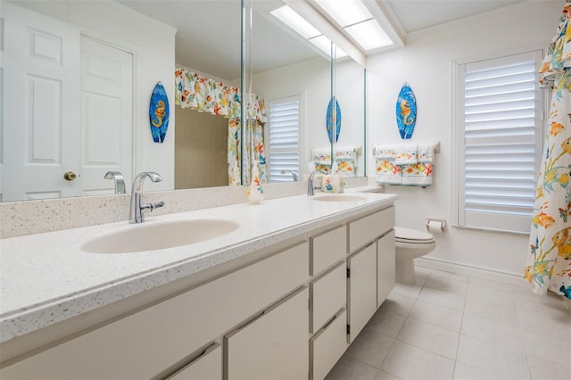 full bath featuring a skylight, double vanity, a sink, and tile patterned floors