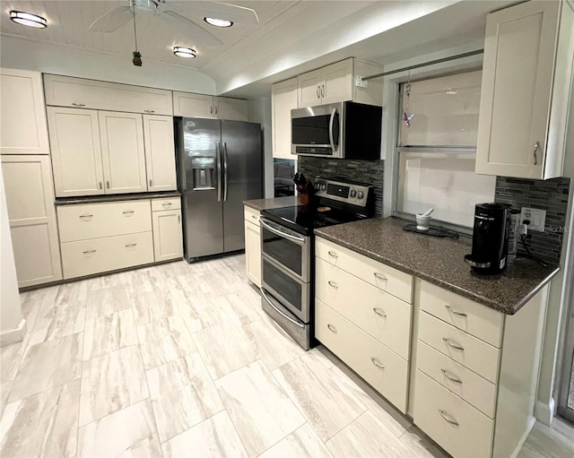 kitchen featuring appliances with stainless steel finishes, dark stone counters, and decorative backsplash