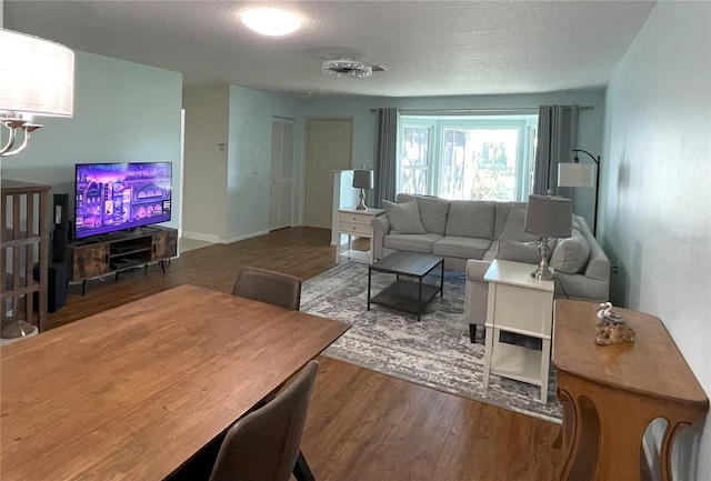 living area with a textured ceiling and wood finished floors