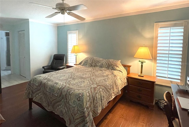 bedroom with ceiling fan, ornamental molding, and wood finished floors