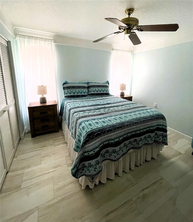 bedroom with a textured ceiling and a ceiling fan