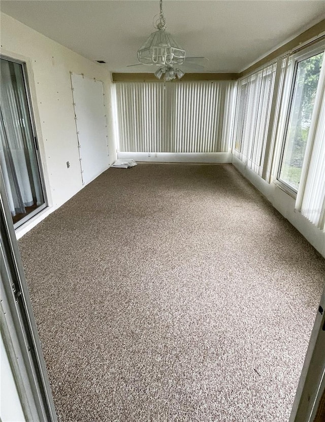 unfurnished sunroom featuring ceiling fan