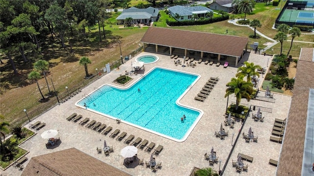 pool featuring fence, a community hot tub, and a patio