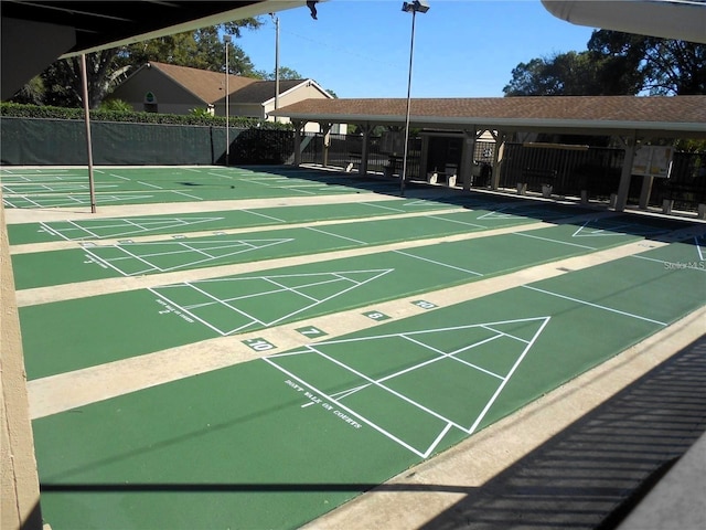 view of home's community with shuffleboard and fence