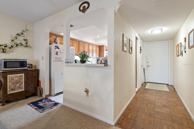 interior space with a textured ceiling and baseboards