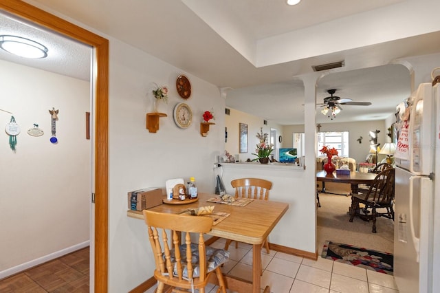 dining room featuring visible vents, ceiling fan, baseboards, and light tile patterned flooring