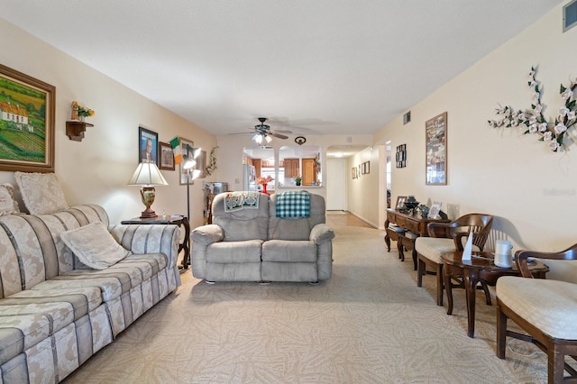 living room with light carpet, ceiling fan, and visible vents