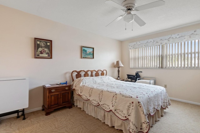 bedroom featuring light carpet, ceiling fan, and baseboards