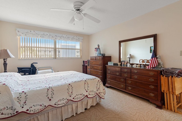 bedroom with a textured ceiling, a ceiling fan, and light colored carpet