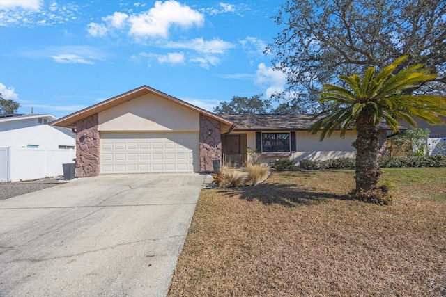 single story home featuring stucco siding, concrete driveway, fence, a garage, and stone siding