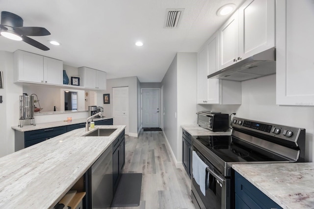 kitchen featuring under cabinet range hood, a sink, visible vents, white cabinets, and appliances with stainless steel finishes