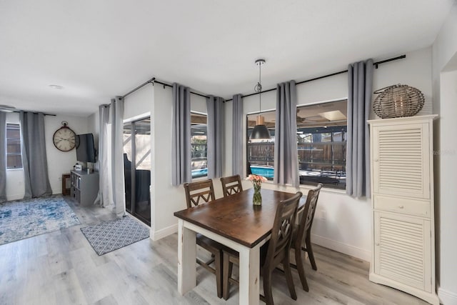 dining area featuring light wood-type flooring and baseboards