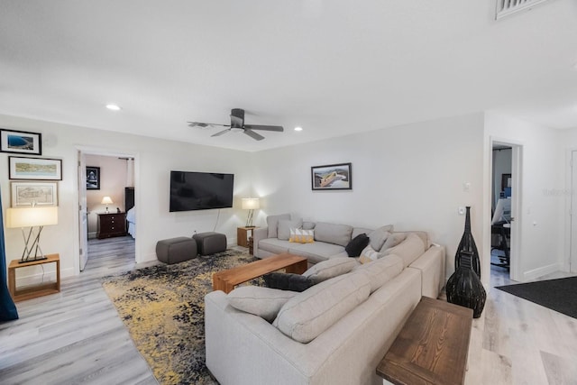 living room featuring light wood finished floors, visible vents, baseboards, ceiling fan, and recessed lighting