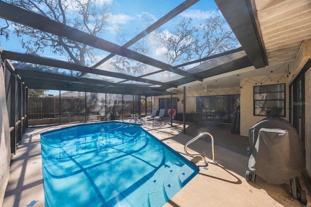 outdoor pool with glass enclosure, a patio area, and a grill