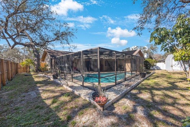 view of swimming pool featuring glass enclosure, a fenced backyard, a fenced in pool, and a yard