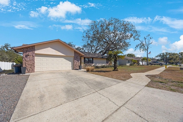 single story home featuring a garage, stone siding, concrete driveway, and stucco siding