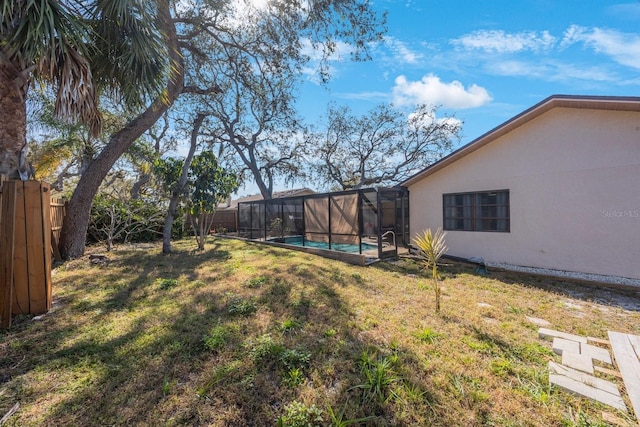 view of yard with glass enclosure, a fenced backyard, and a fenced in pool