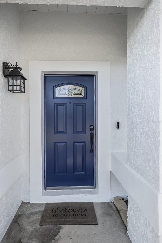 property entrance with stucco siding