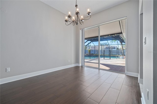 unfurnished room with wood finished floors, baseboards, and a sunroom