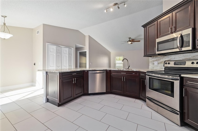 kitchen with dark brown cabinets, lofted ceiling, decorative backsplash, appliances with stainless steel finishes, and a peninsula